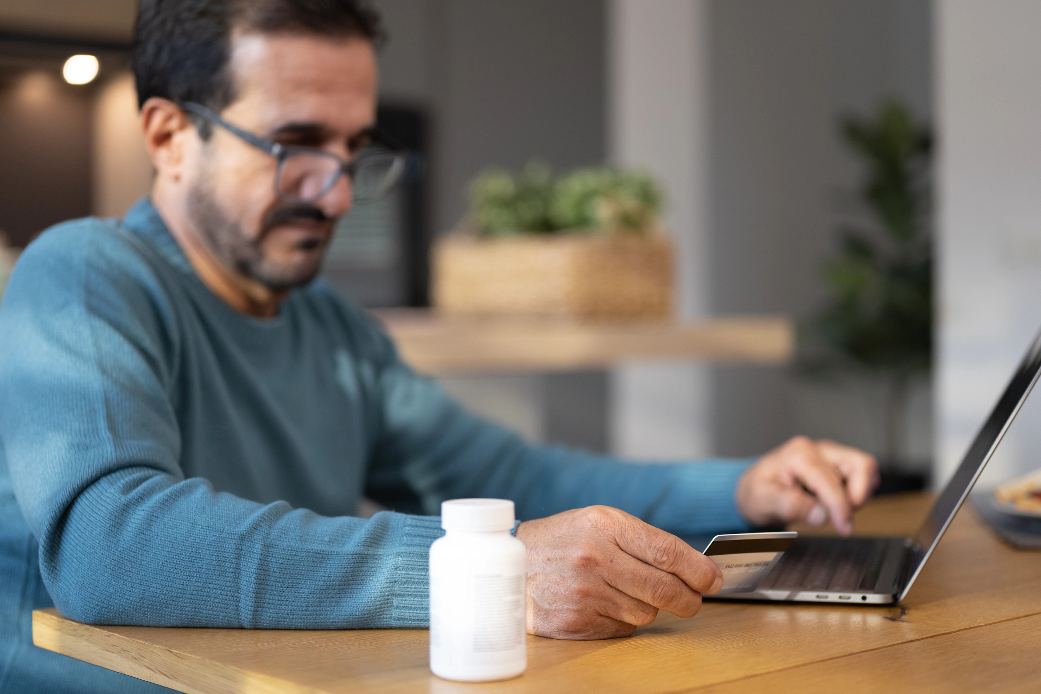 a person on a computer with a white pill bottle