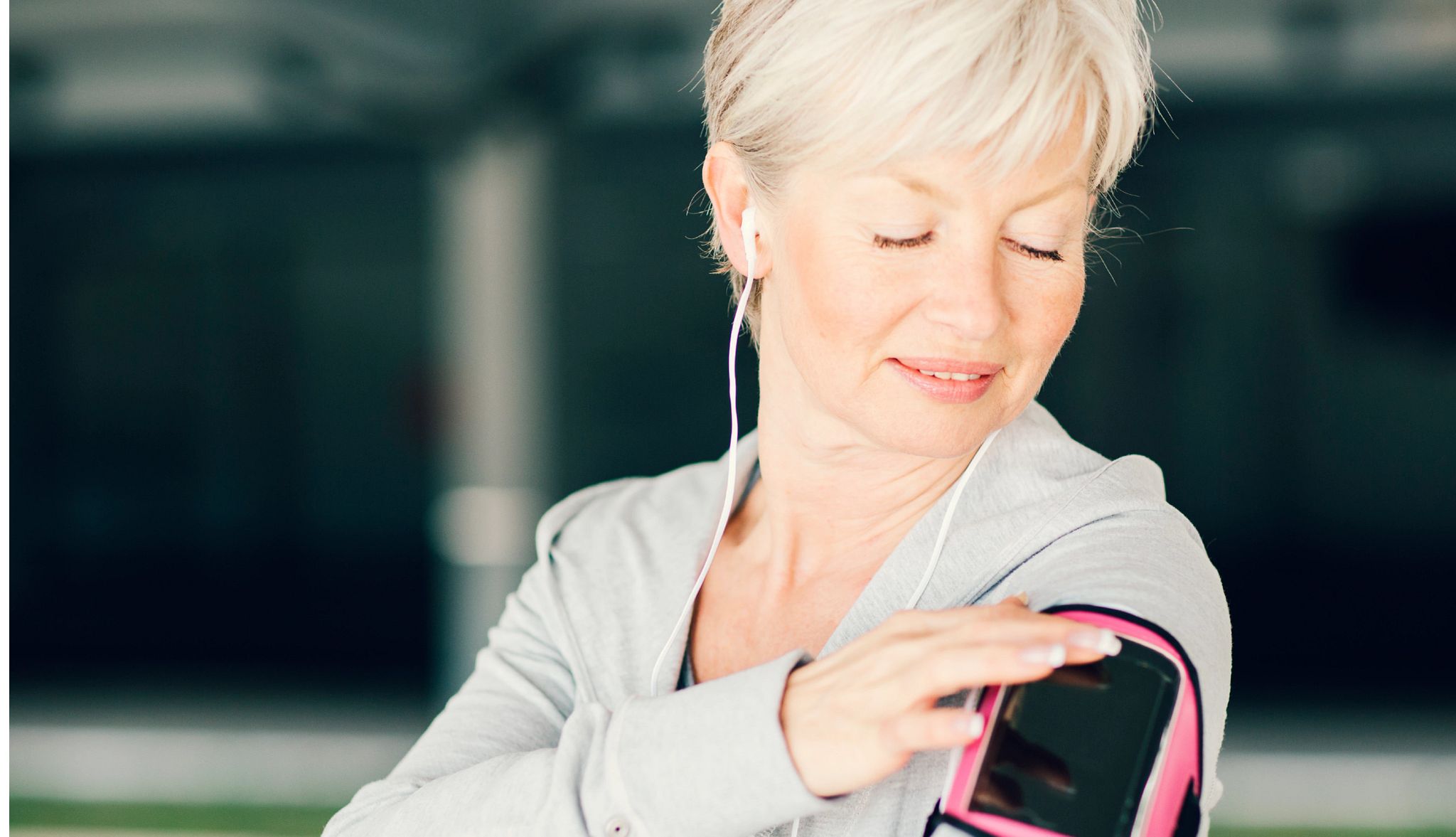 Mature Woman Running and listening to music on her smart phone. Mature Woman Running and listening to music on her smart phone.