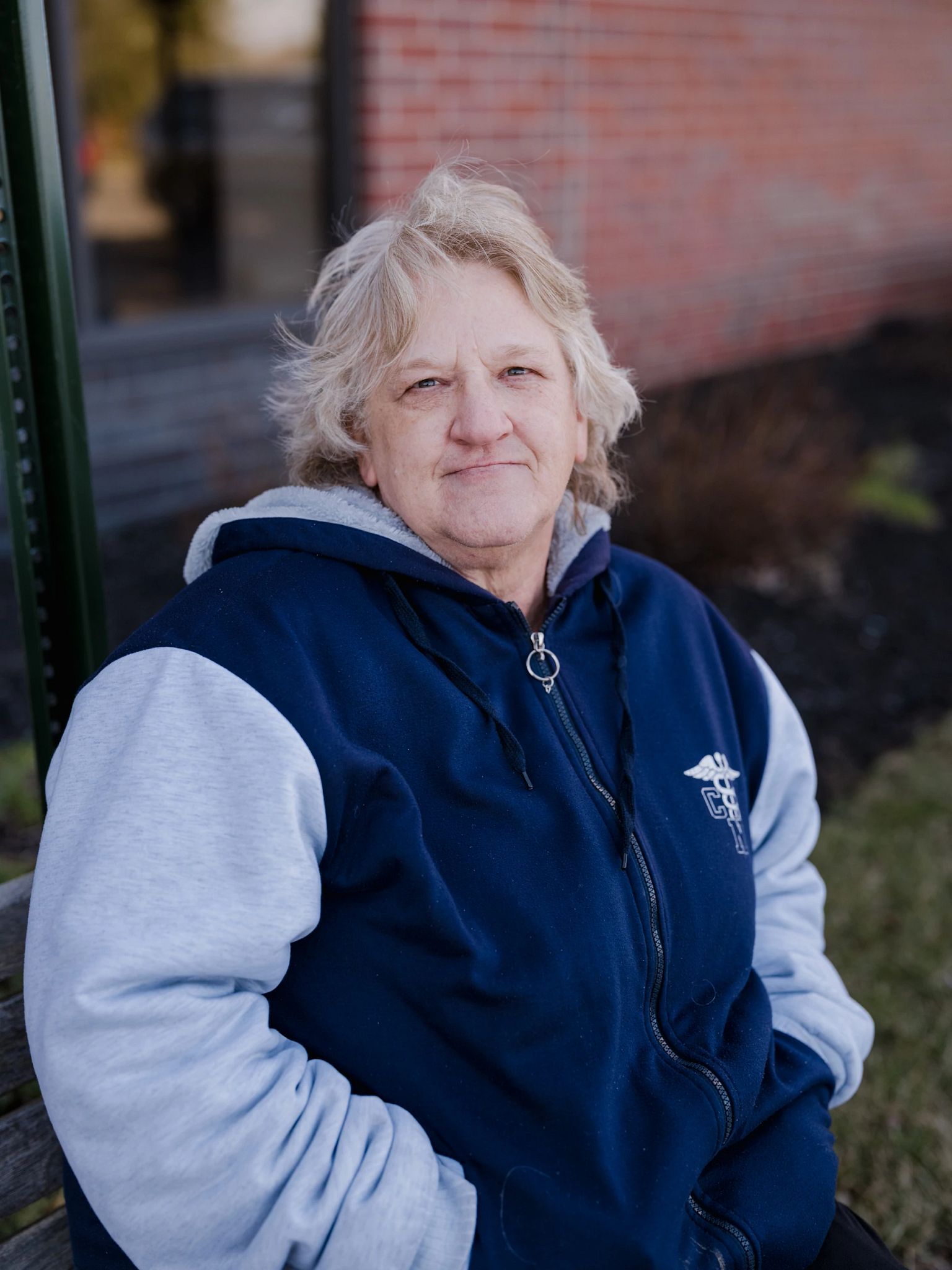 Social Security customers deborah gilbert-mann wears a blue and gray jacket outside an office