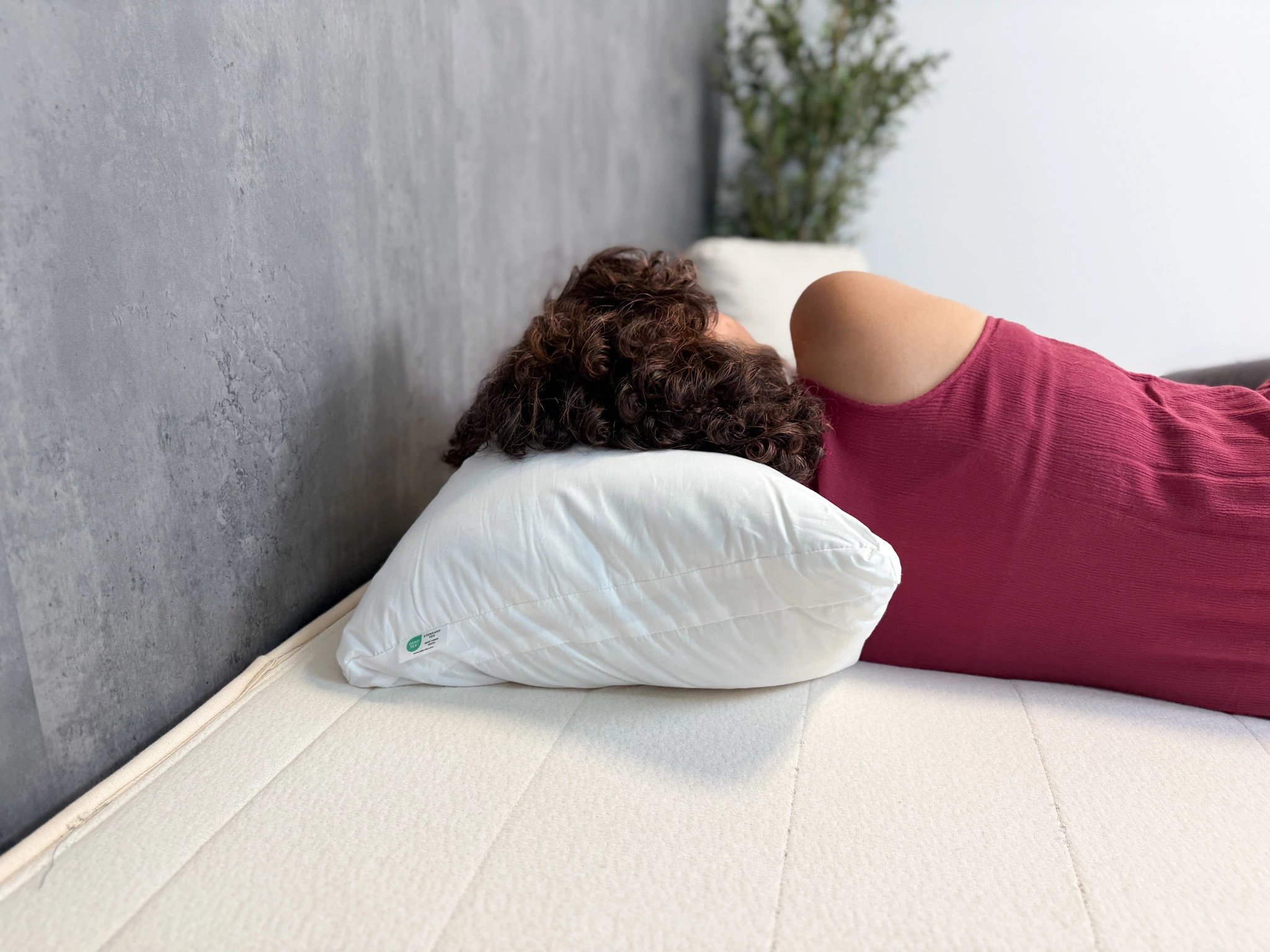 A woman sleeping on her side with her head on the Silk & Snow Adjustable Pillow 