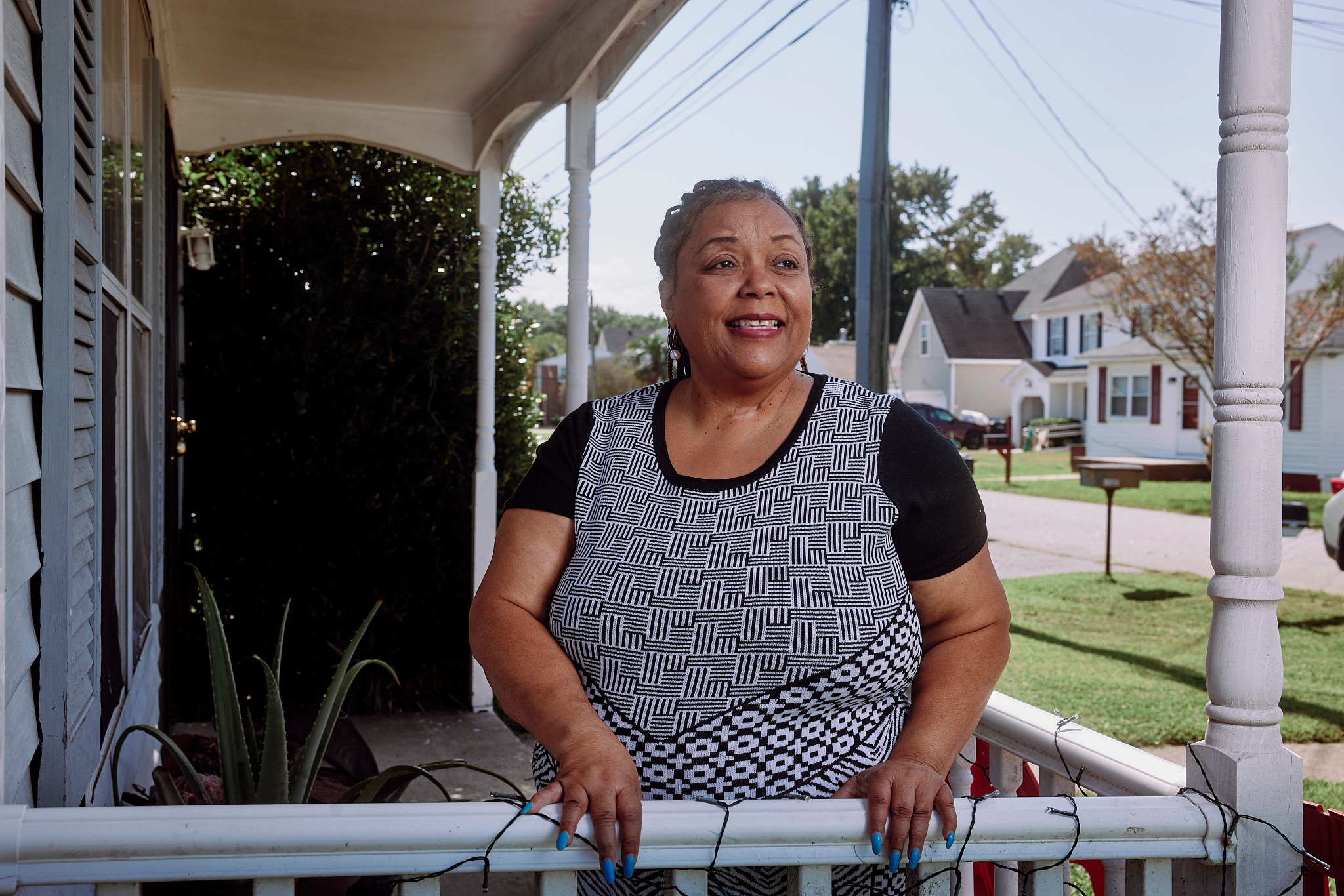 Una mujer parada en el balcon de su casa