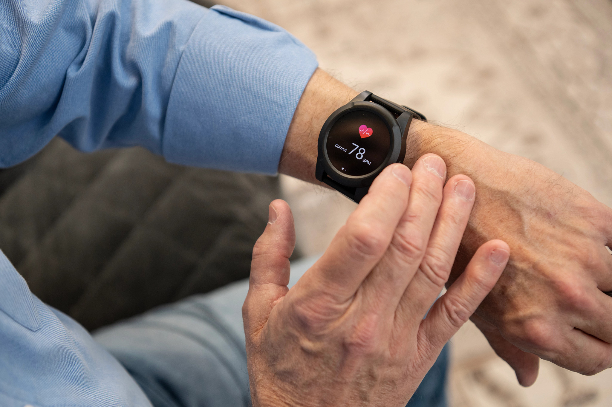A person with the Safe Watch Active on their wrist with their opposite hand near the watch display screen