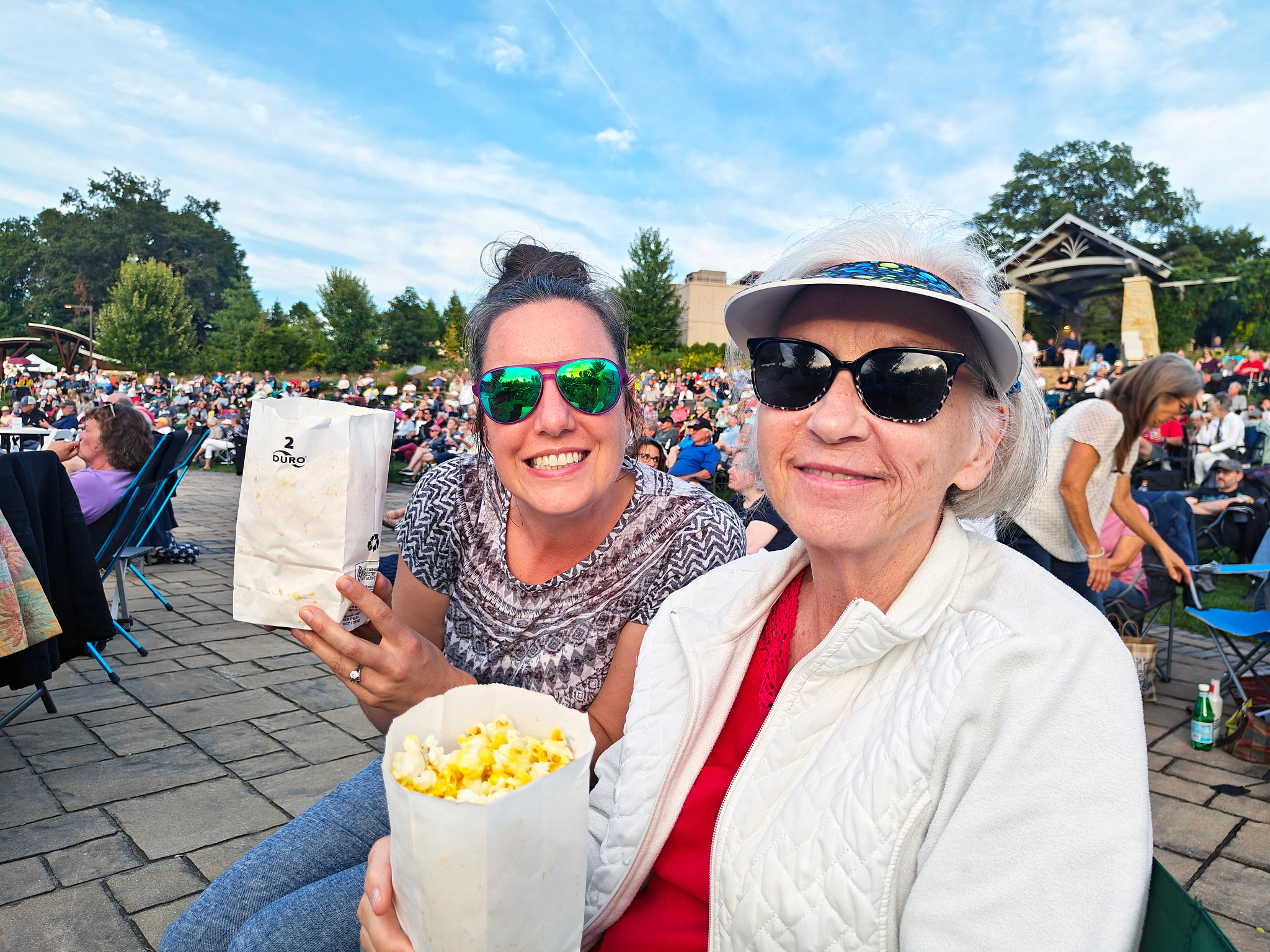 dos personas en un concierto al aire libre comiendo palomitas de maíz