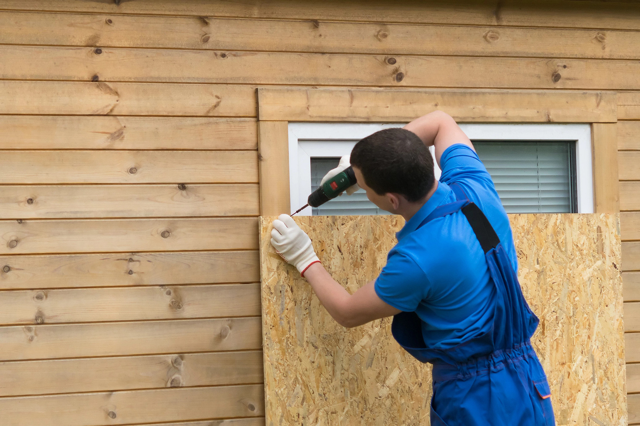 a man closes a window in a house before a long departure