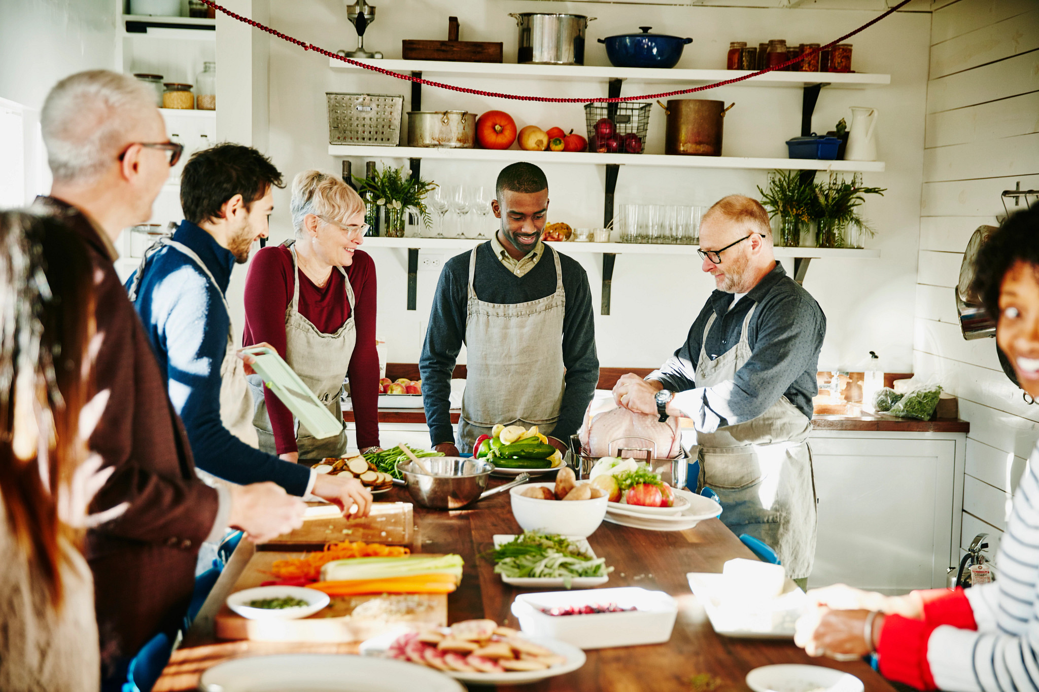 Chef teaching group of friends how to preparing turkey during cooking class