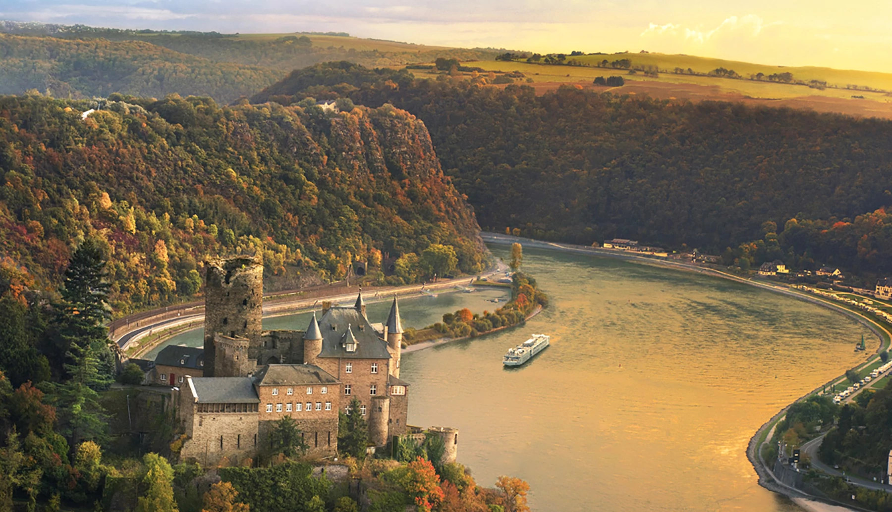 a landscape of grass cliffs, a castle and a cruise in the water