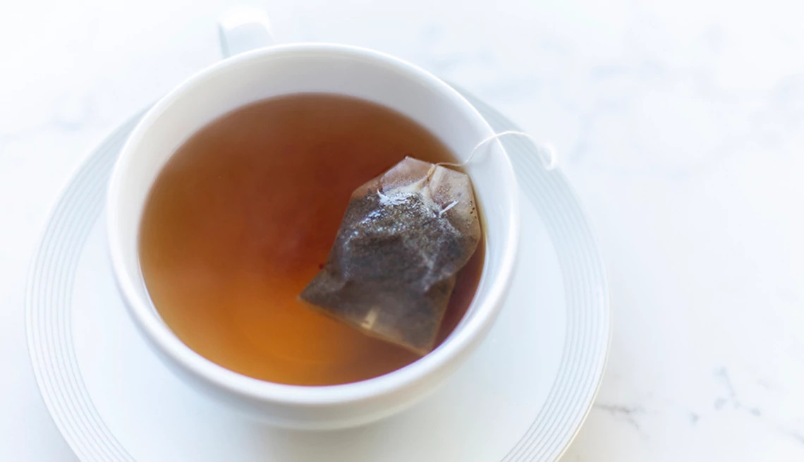 A close-up view of a cup of tea with a teabag in it