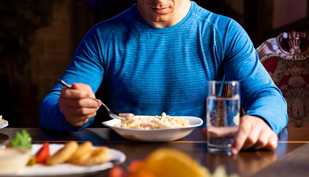 Self-compassion is linked to healthy behaviors such as eating well A man eating a pasta dish at a table