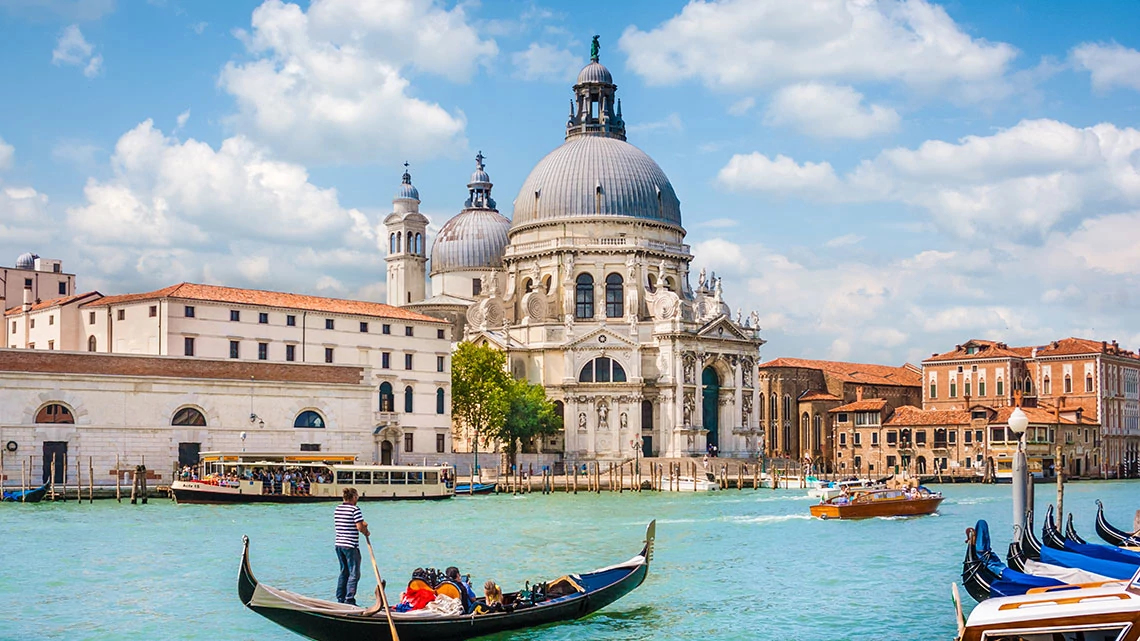 Grand European Travel: Vacation Packages river with boats and gondola city scape behind