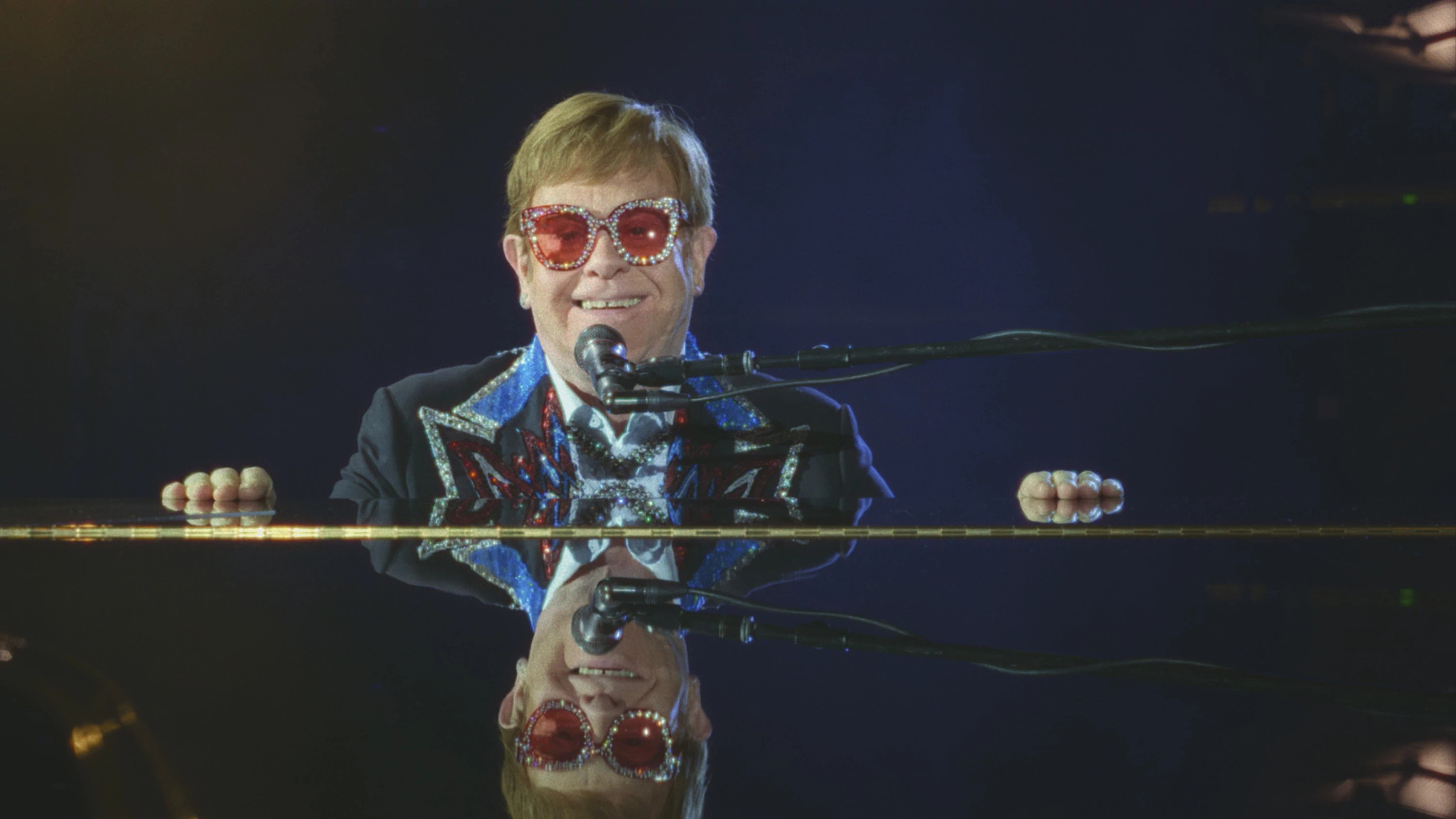 Elton John sitting at a piano