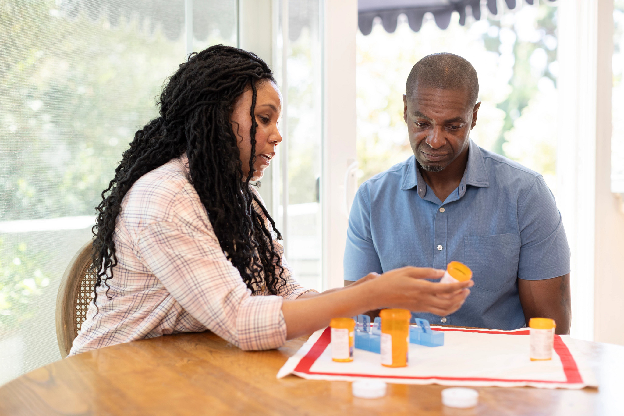 A woman discussing medication with another individual.