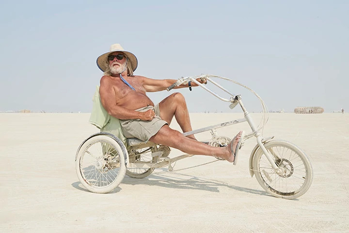 a man sitting on a bicycle in the desert