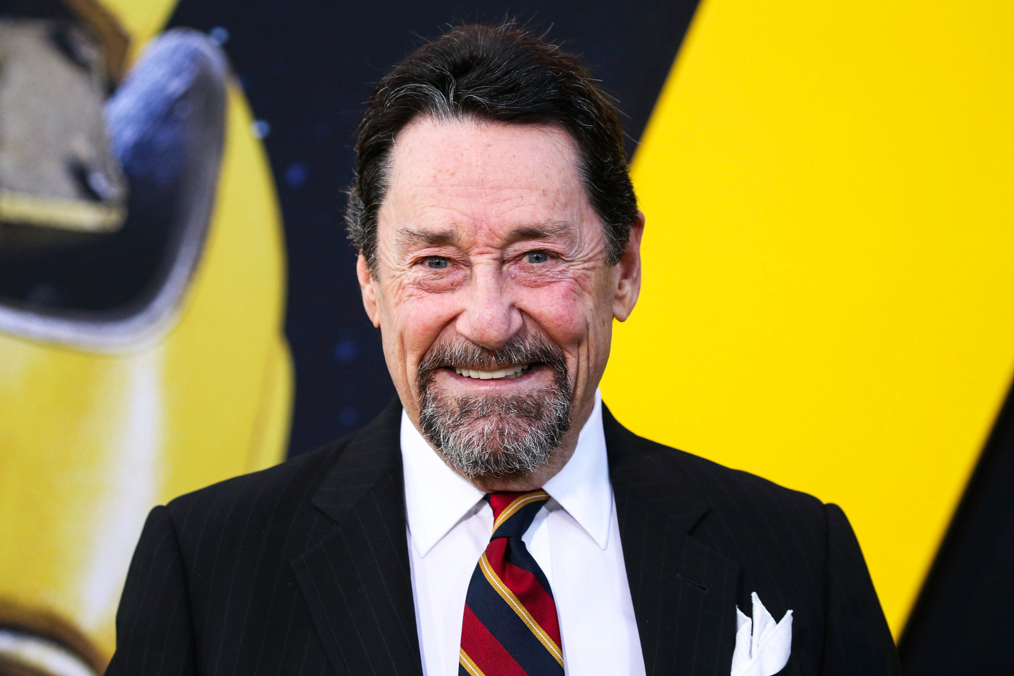 head shot of peter cullen in a suit and tie