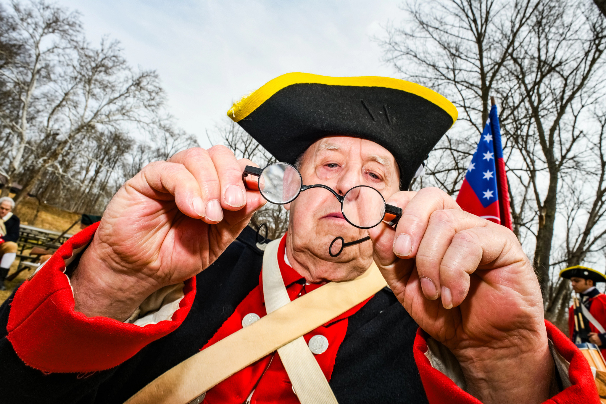 a Revolutionary War reenactor looking at his glasses
