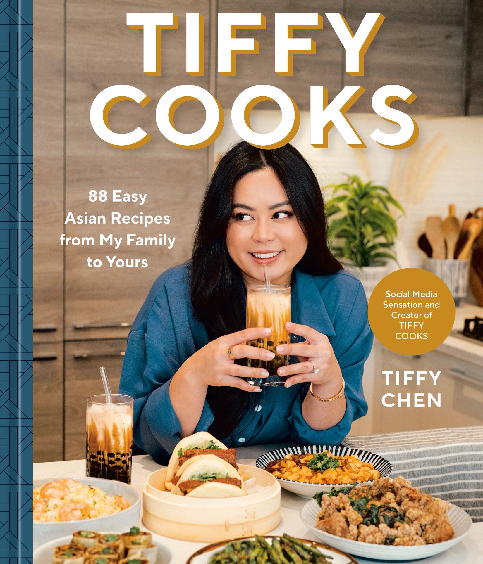 Cookbook 'Tiffy Cooks: 88 Easy Asian Recipes From My Family to Yours' by Tiffy Chen Cookbook that says Tiffy Cooks, 88 Easy Asian Recipes From My Family to Yours, Tiffy Chen; Tiffy Chen on cover with a bunch of food on table in front of her, holding drinking glass up to mouth