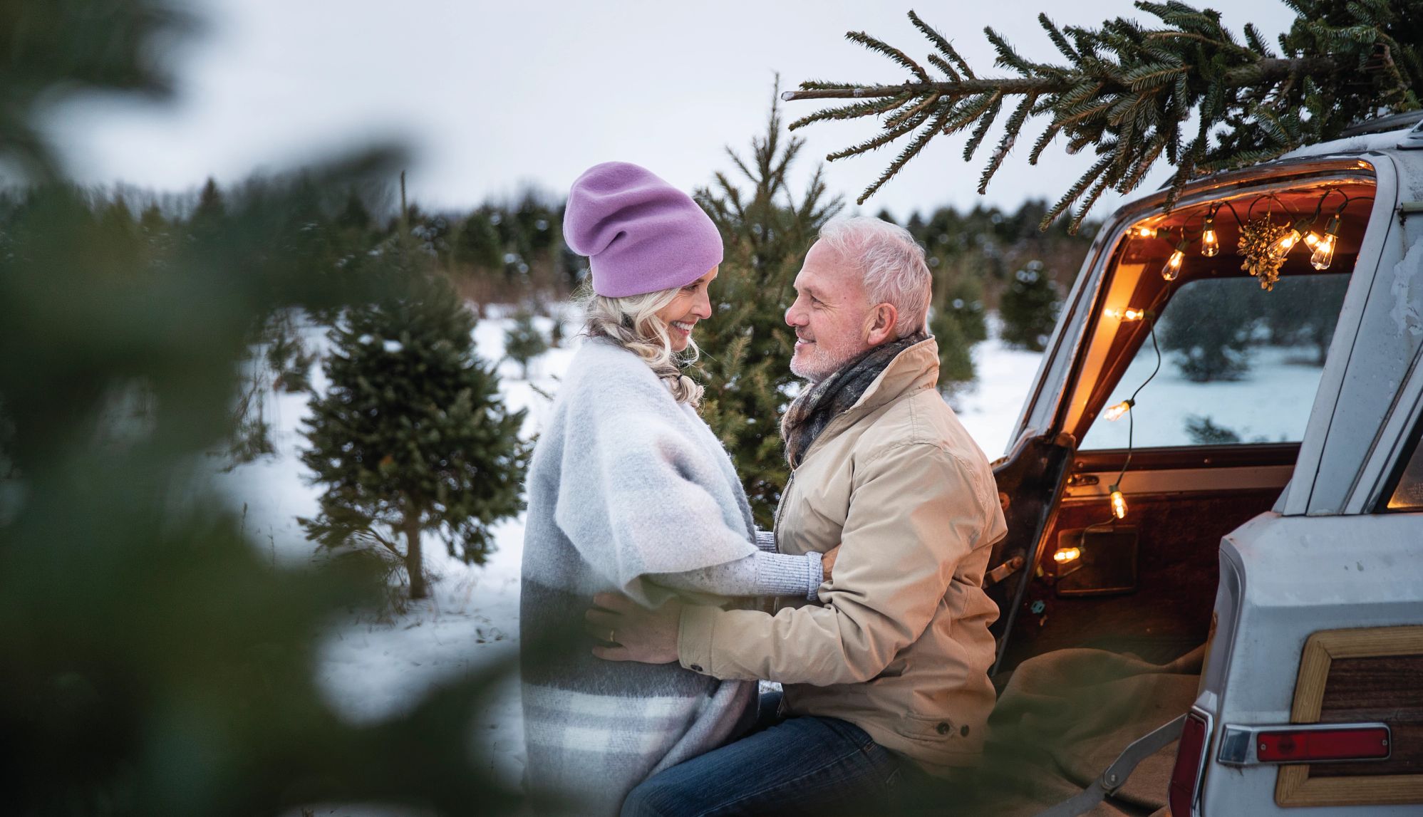 Small Towns Embody Hallmark Christmas Movies a man and woman looking at each other on a christmas tree farm