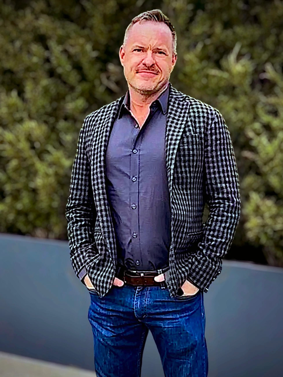a photo shows writer Adam Turner standing outside in a leather jacket