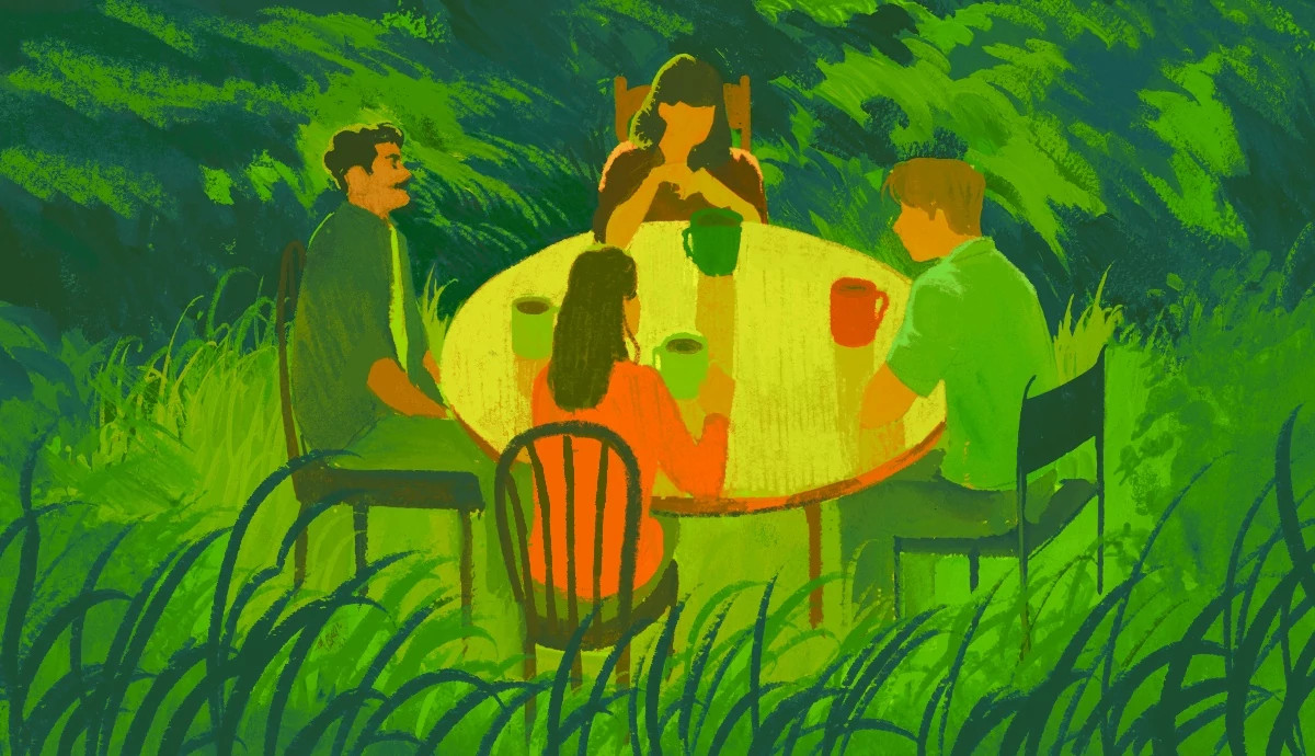 Four people seated at an outdoor table engage in a talking circle