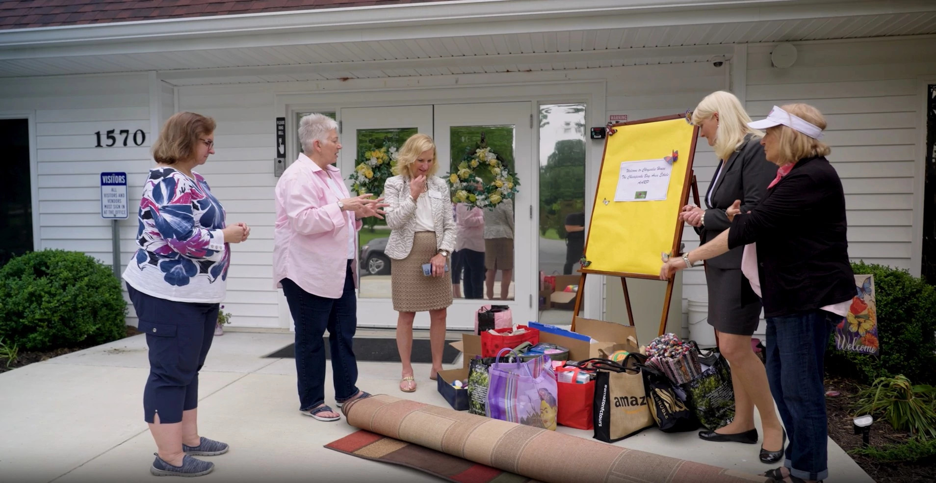 A group of women standing and discussing a pile of donations