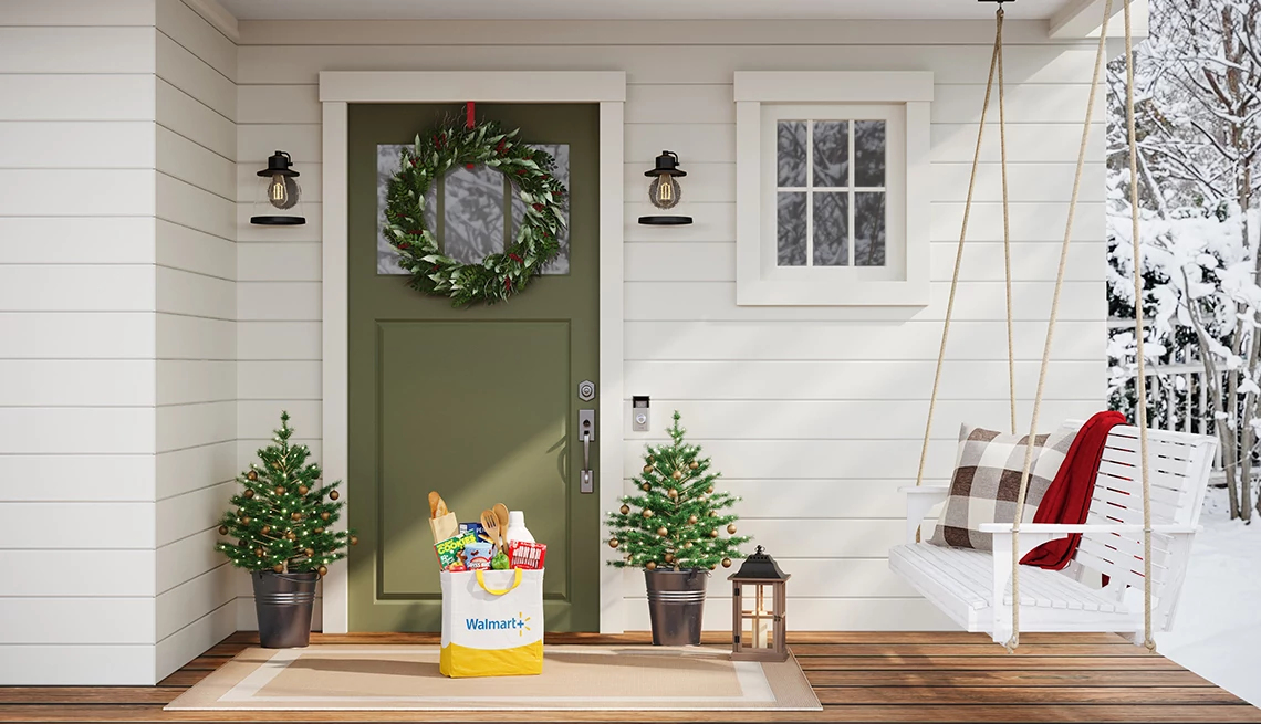 Walmart+ shopping bag sitting on porch surrounded by holiday decorations