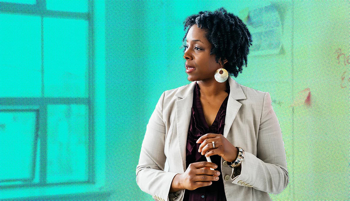 Professional woman wearing a light blazer and statement earrings in a contemporary office setting
