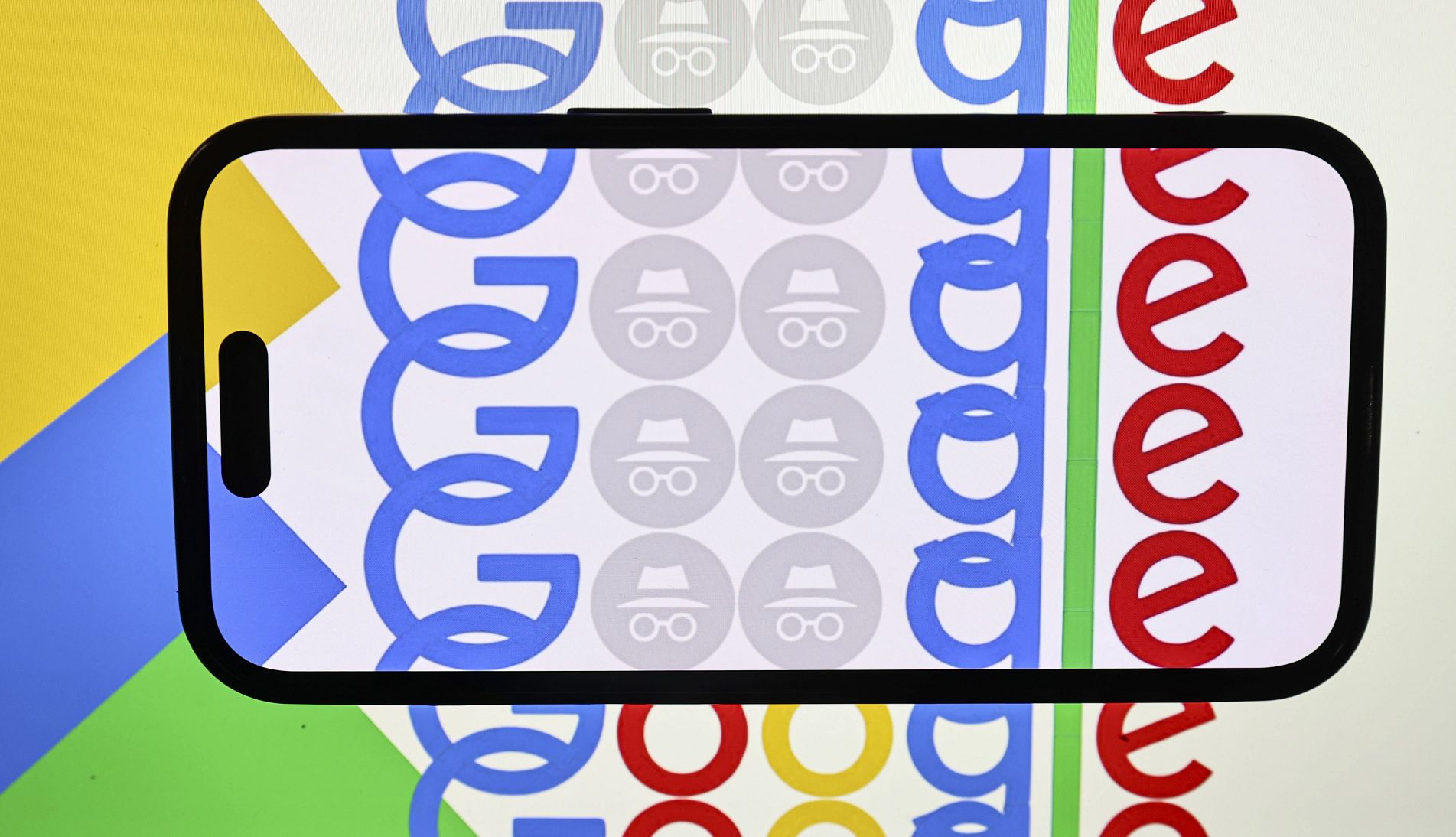 Google agrees to delete private browsing records Google logo projected behind the outline of a smartphone
