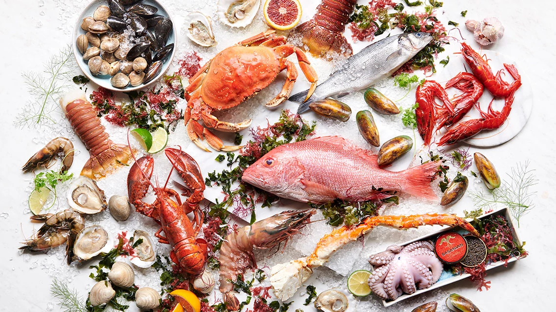 Landry's, Inc Restaurants raw fish, lobster, octopus, crab, clams, oysters, shrimp, prawns, snow crab legs, lemon, lime, orange on bed of ice