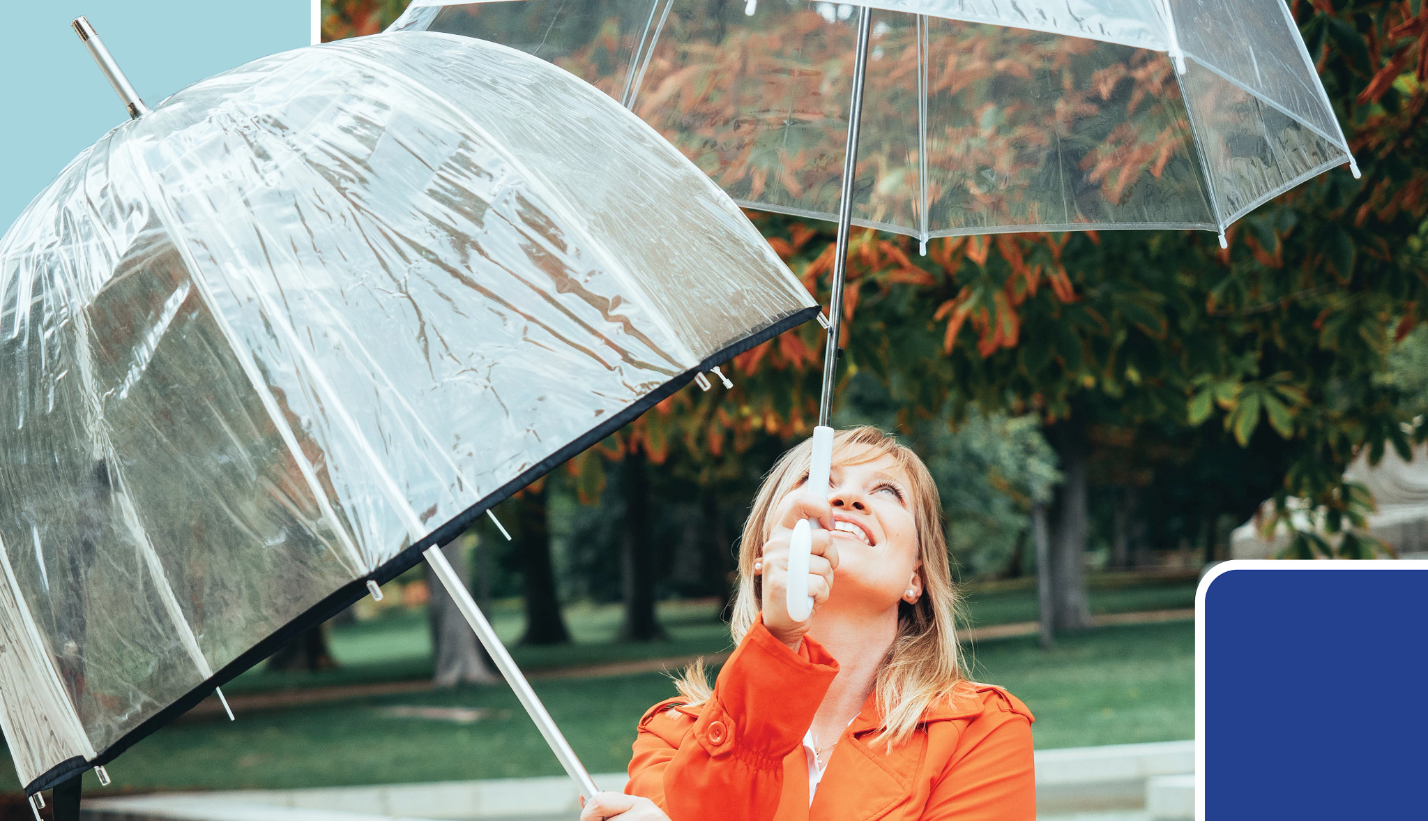 Two red umbrellas are positioned side by side on a warm orange background