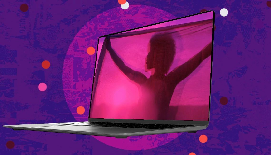 Se ve la silueta de una mujer en la pantalla de una computadora contra un fondo morado y rosado.