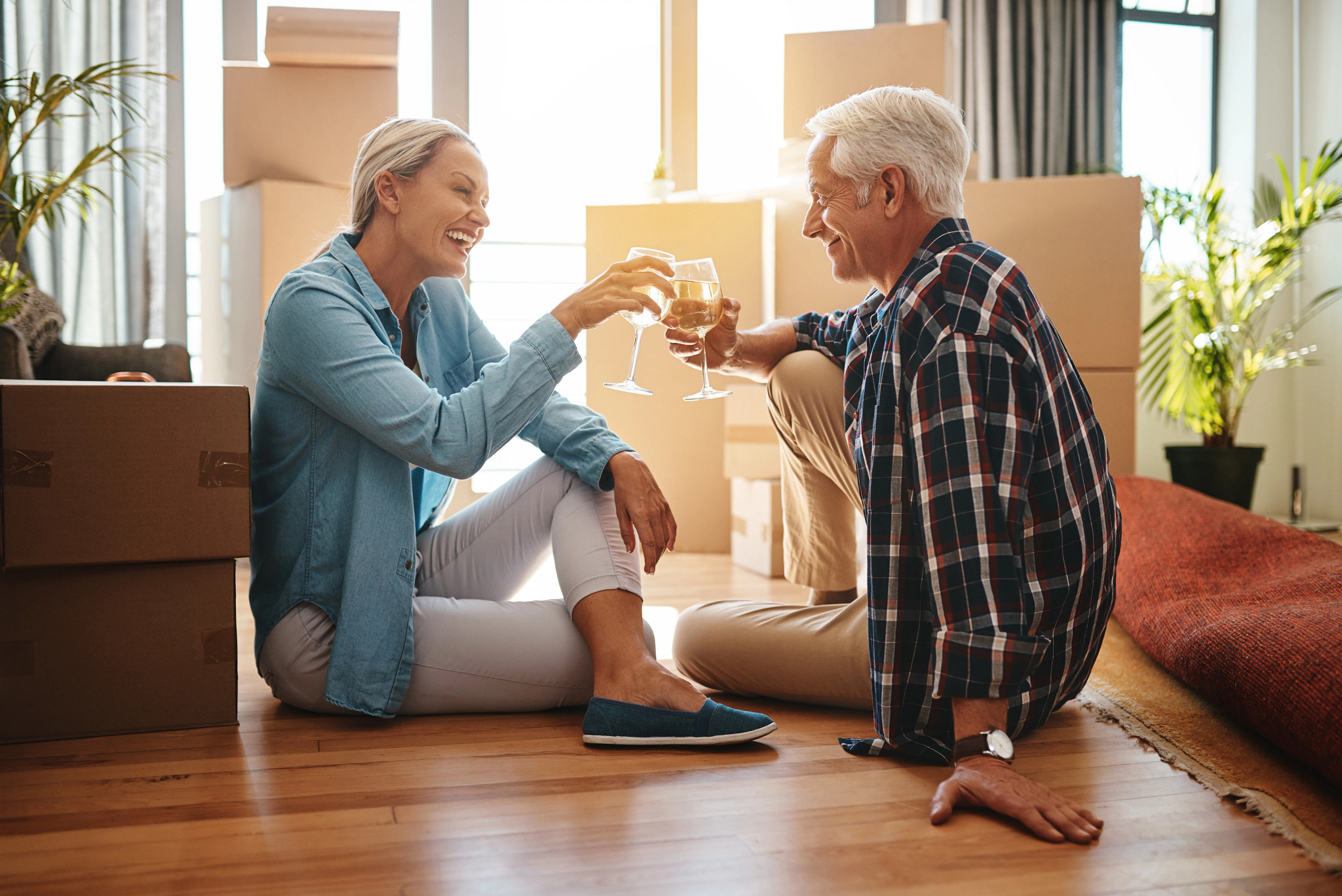 an older couple toasts with glasses of white wine