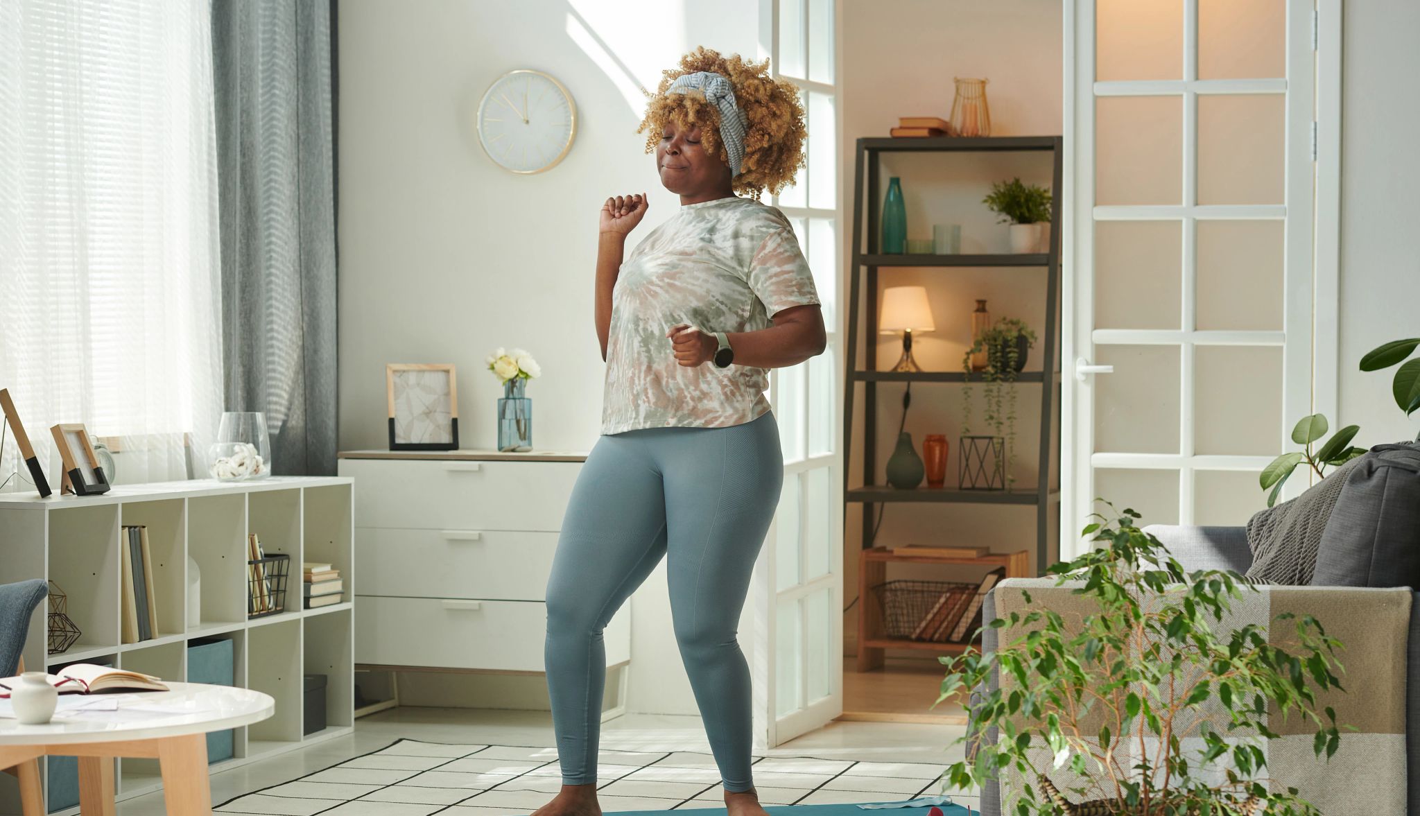 African girl standing on exercise mat and dancing to music during sports training at home African girl standing on exercise mat and dancing to music during sports training at home