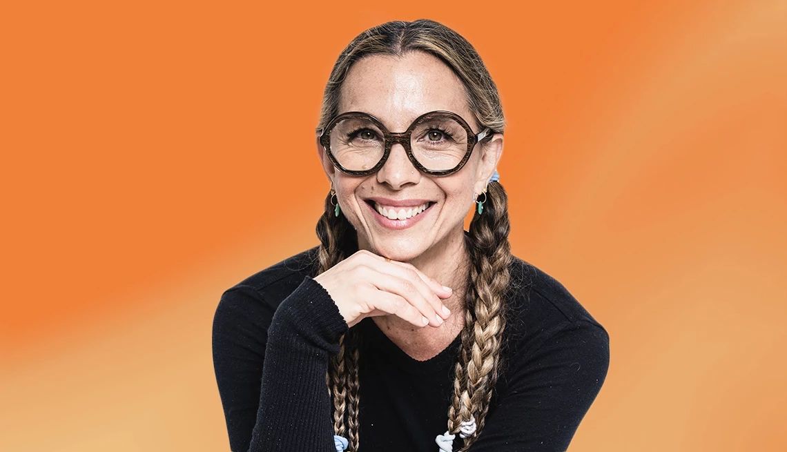 Moon Unit Zappa’s New Memoir Addresses Family Rift  Moon Unit Zappa wearing dark-rimmed glasses and with hair in braids against an orange ombre background
