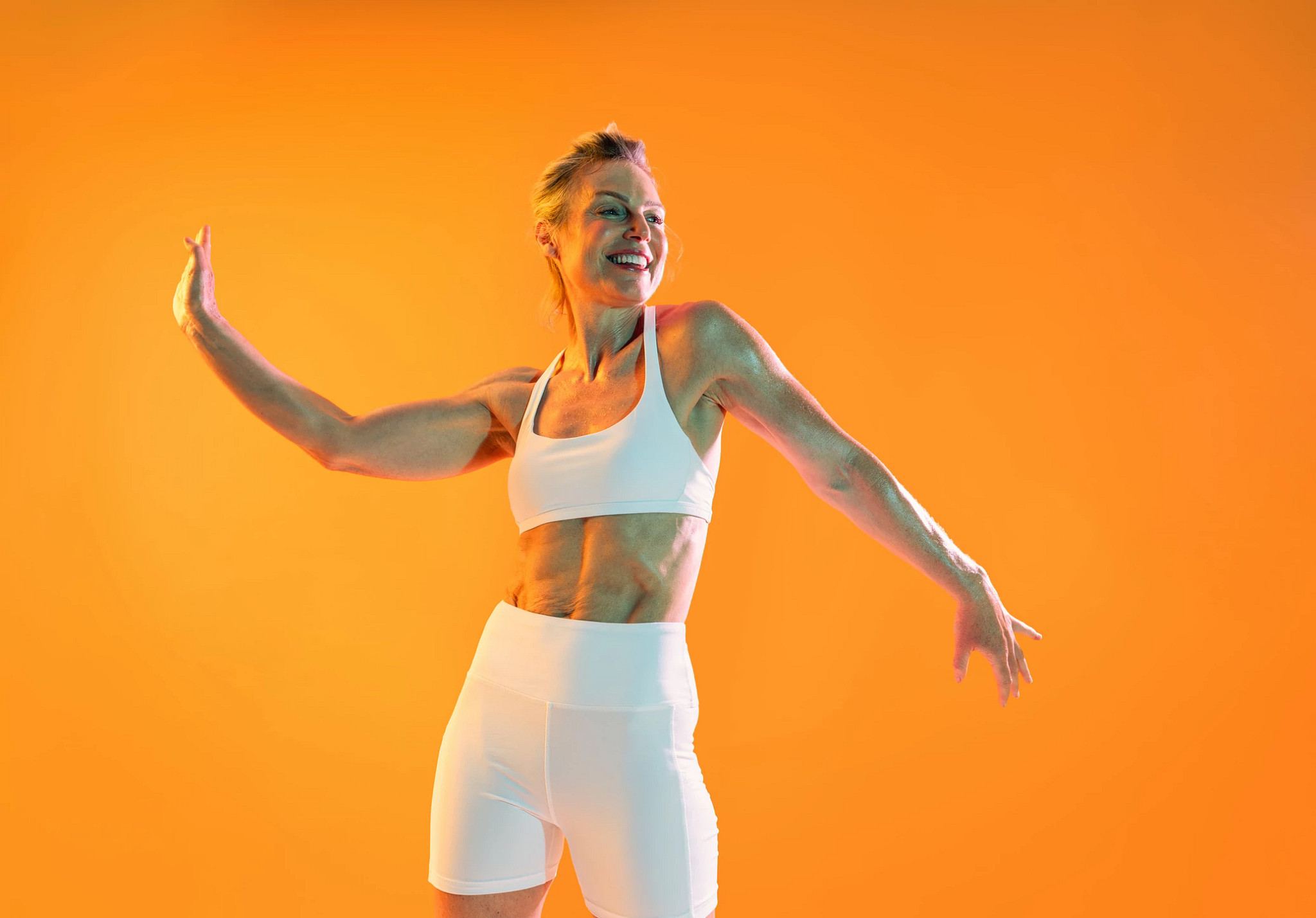 Person wearing white athletic apparel performing a dynamic fitness movement.