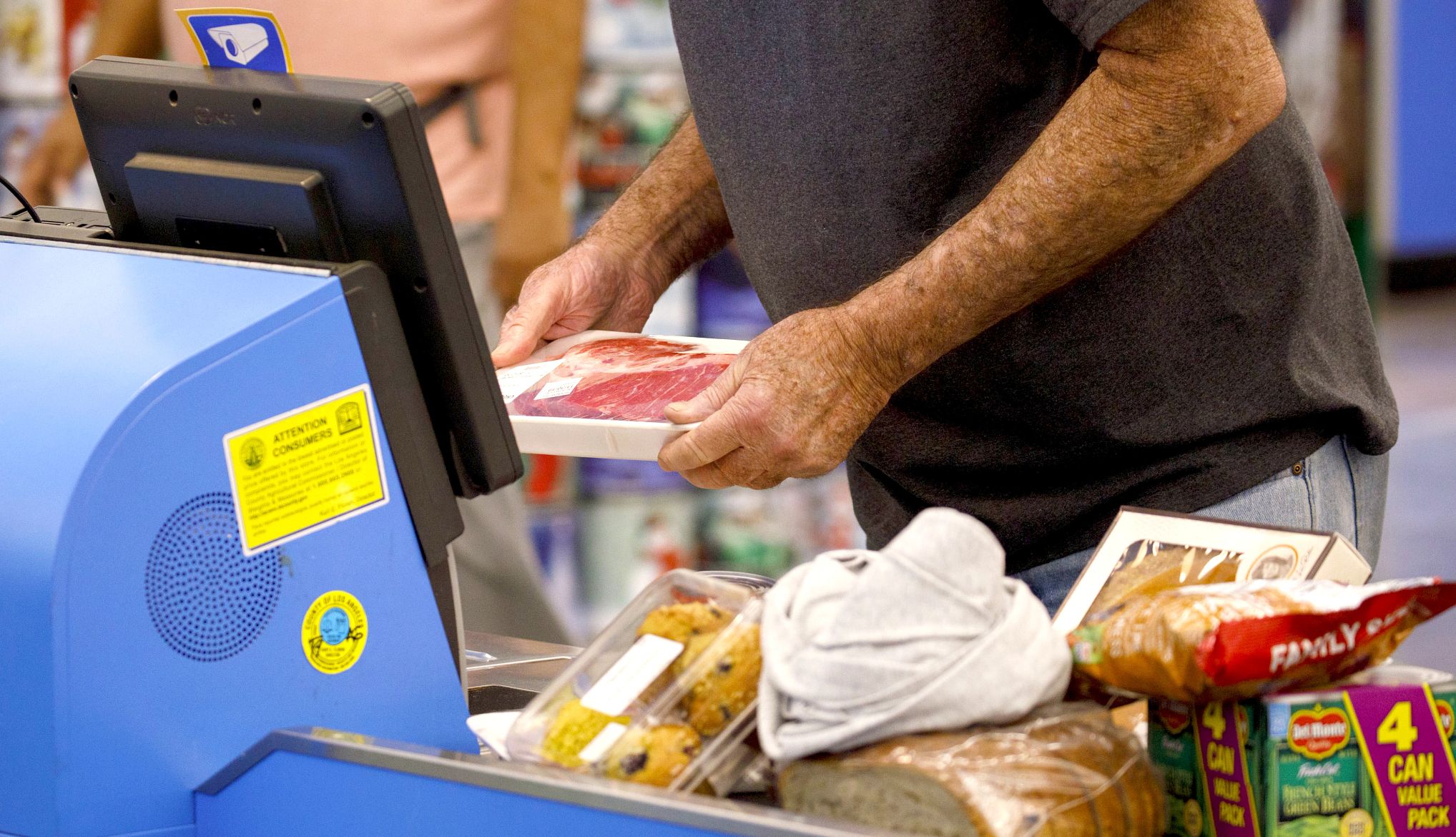 a man buys steak and other groceries