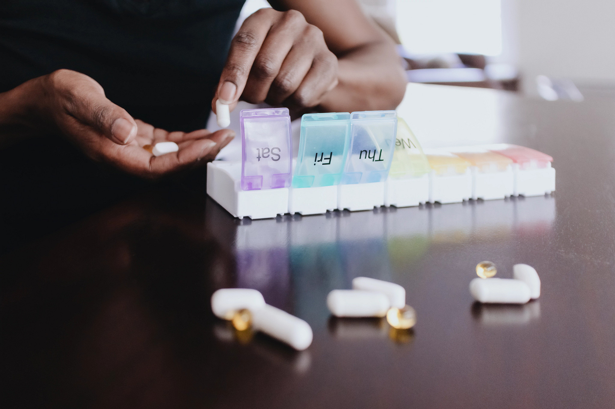 a person sorting pills into an organizer