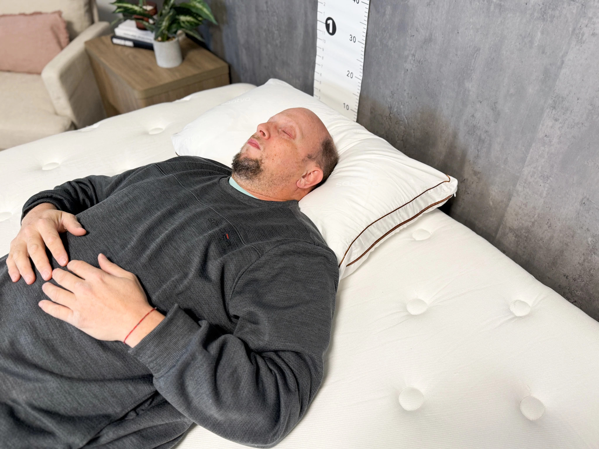 A man lying on his back on the Saatva Latex Pillow.