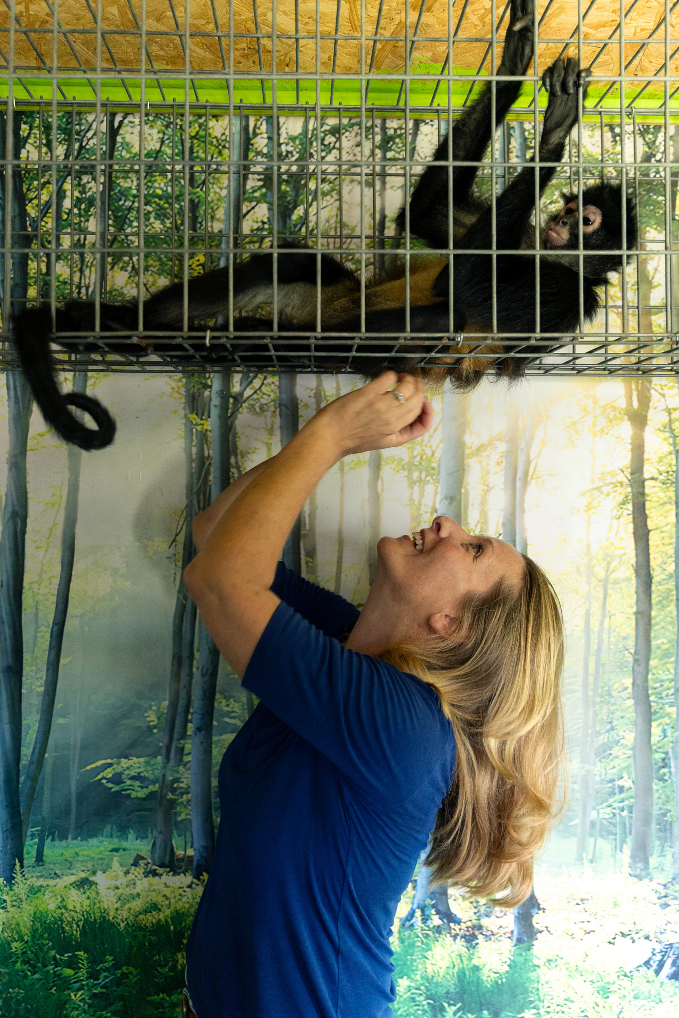 a photo shows April Stewart having fun with a monkey in a cage at the Gulf Coast Primate Sanctuary