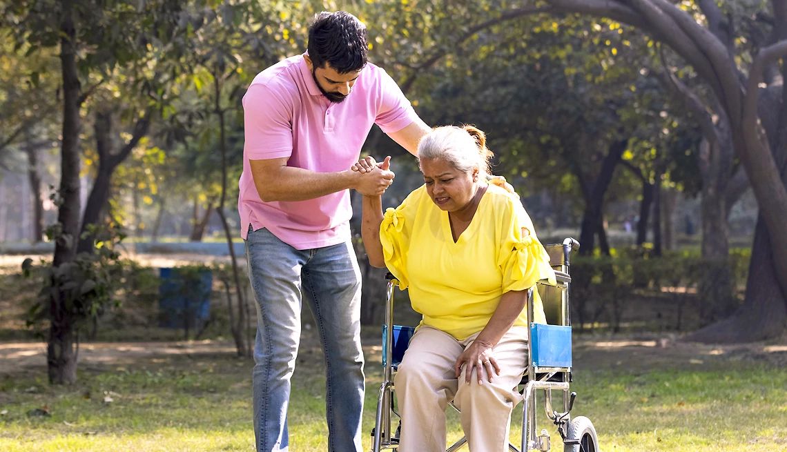 Immigrant family caregivers a caregiver helps an adult out of a wheelchair