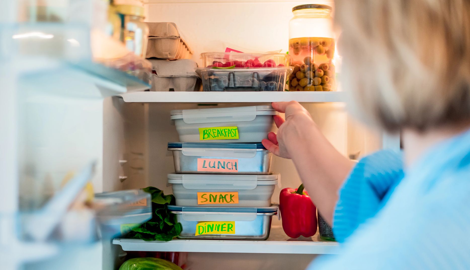 Healthy diet plan for weight loss, daily ready meal menu. Woman taking, putting breakfast box cooked in advance, ready to be served into fridge. Containers with eco healthy food. Pre-cooking concept