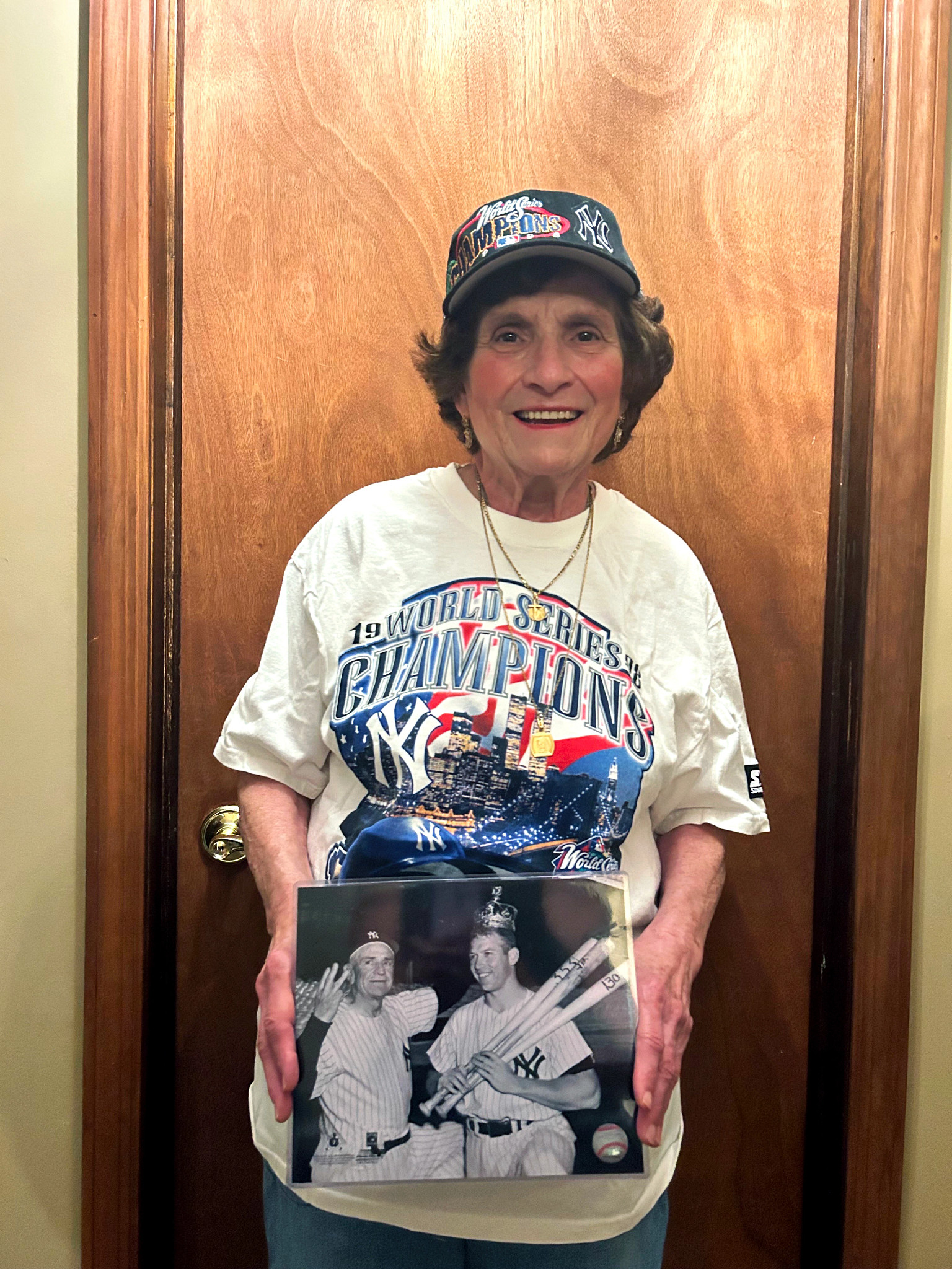 a photo shows the author's mother, Annamaria, wearing a Yankees shirt, holding a favorite iconic photo of manager Casey Stengel and Mickey Mantle