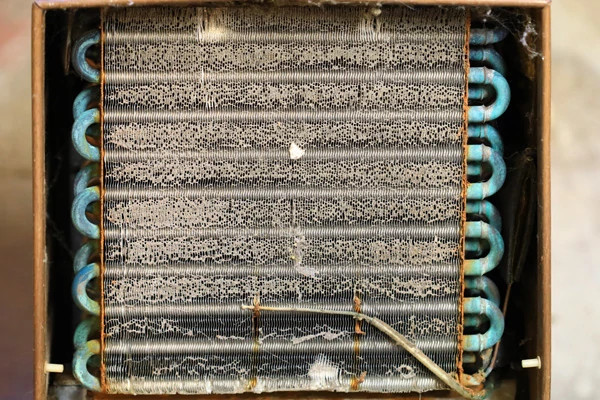 Image of refrigerator coils covered in dust.