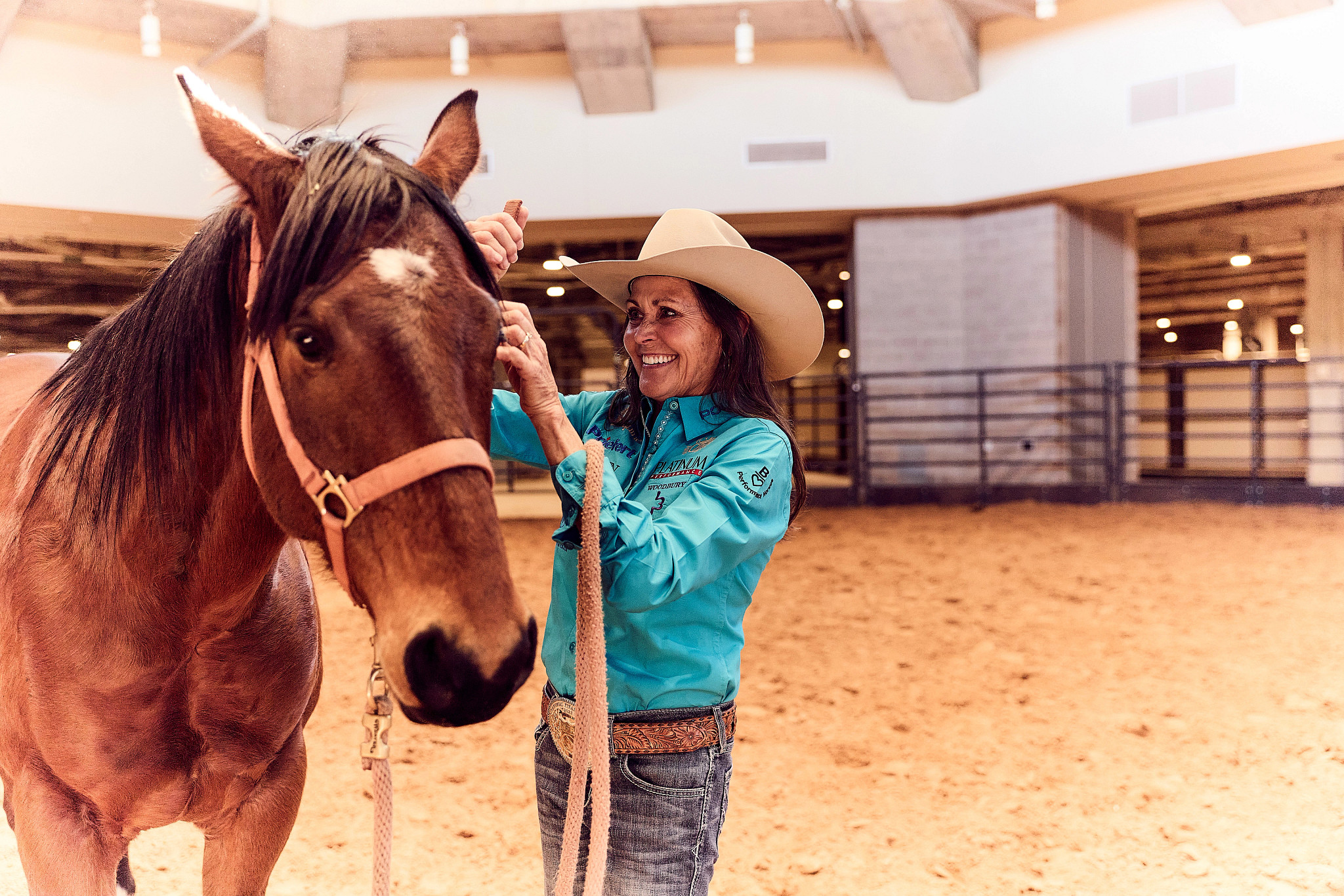 a photo shows Lisa Lockhart attending to a horse