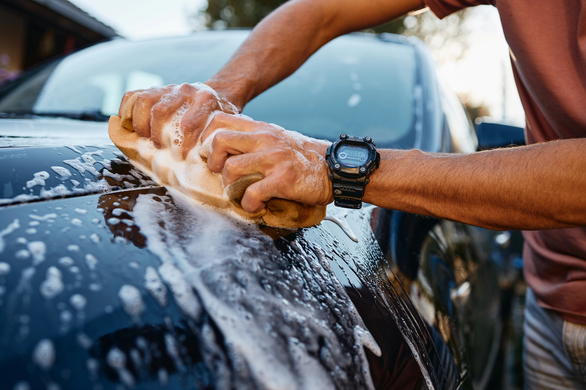 a photo shows a man washing a car