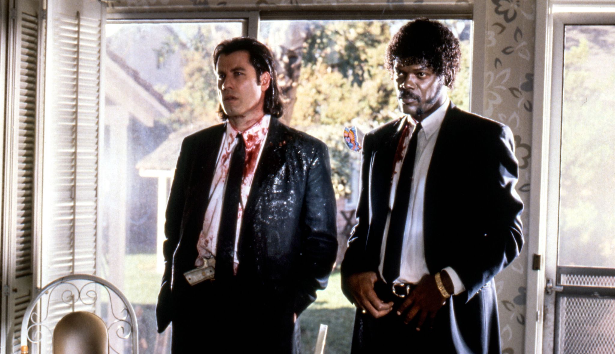 Pulp Fiction John Travolta and Samuel L. Jackson standing next to each other with their suits bloodied in the film Pulp Fiction