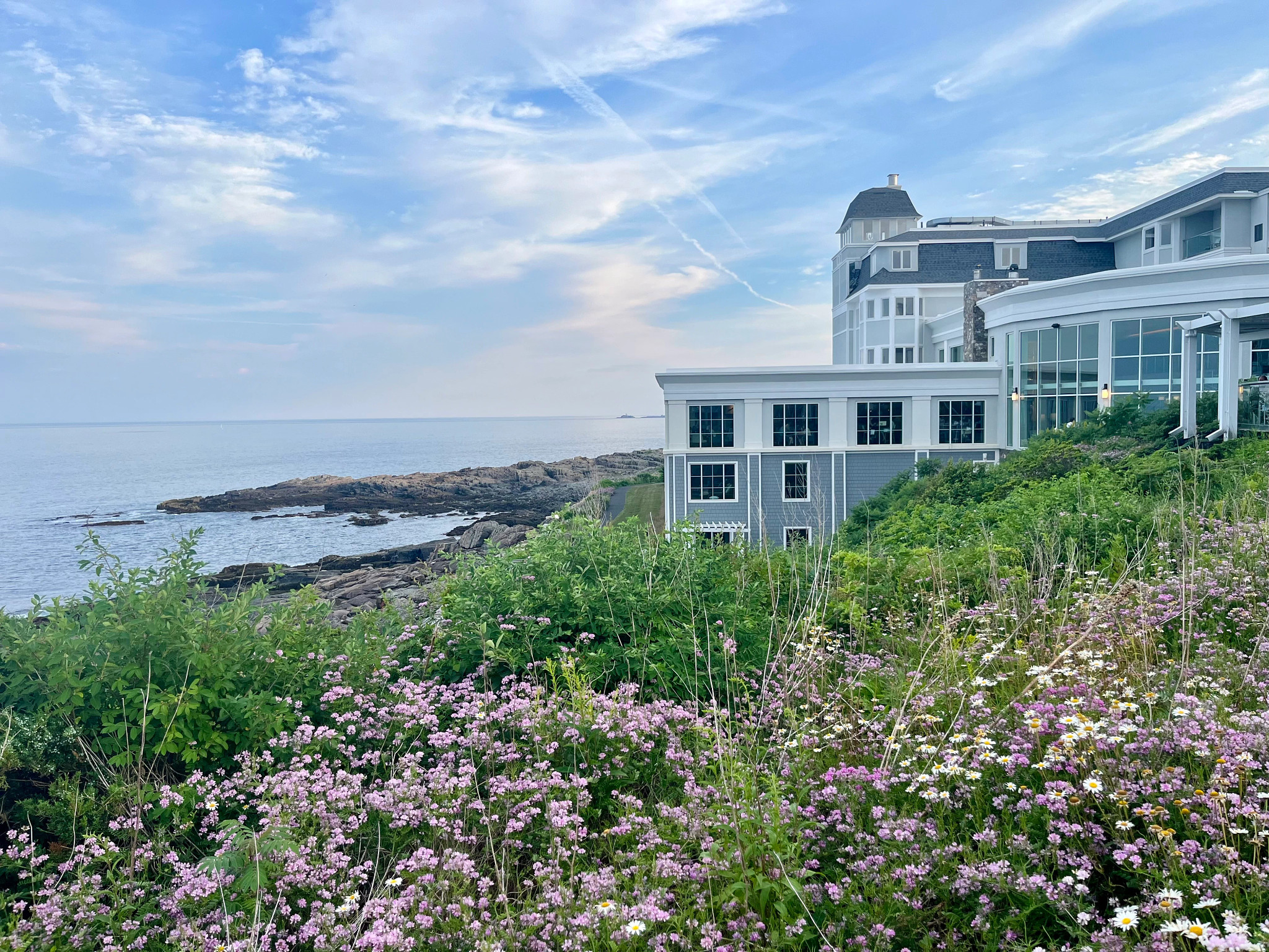 View of Cliff House in Cape Neddick, Maine, surrounded by blooming flowers