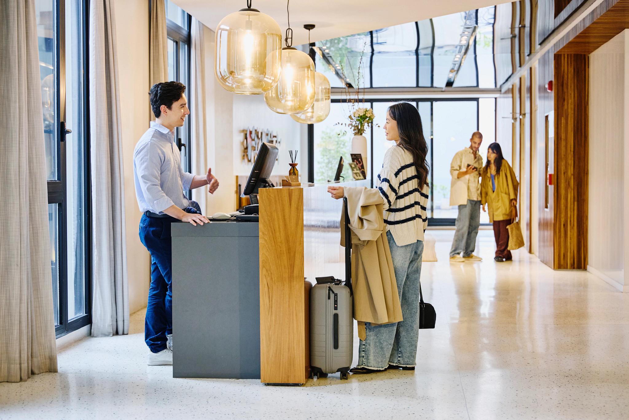 a woman and man talking at a hotel counter