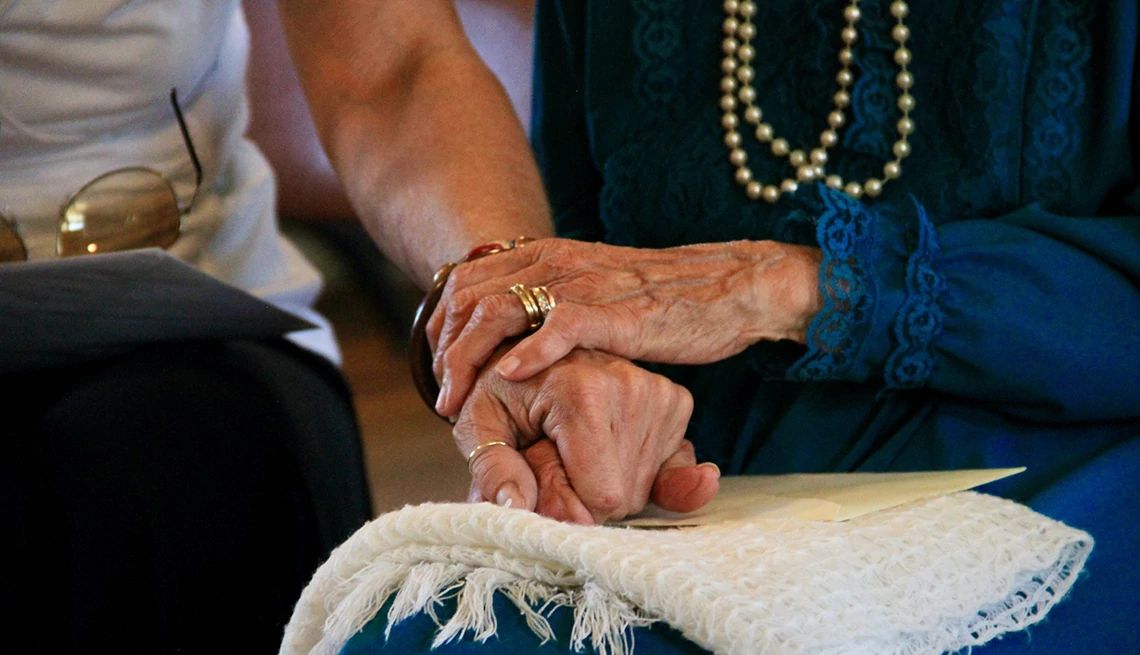 People with brain disorders may be in need of care services A close-up view of the hands of two people holding one another