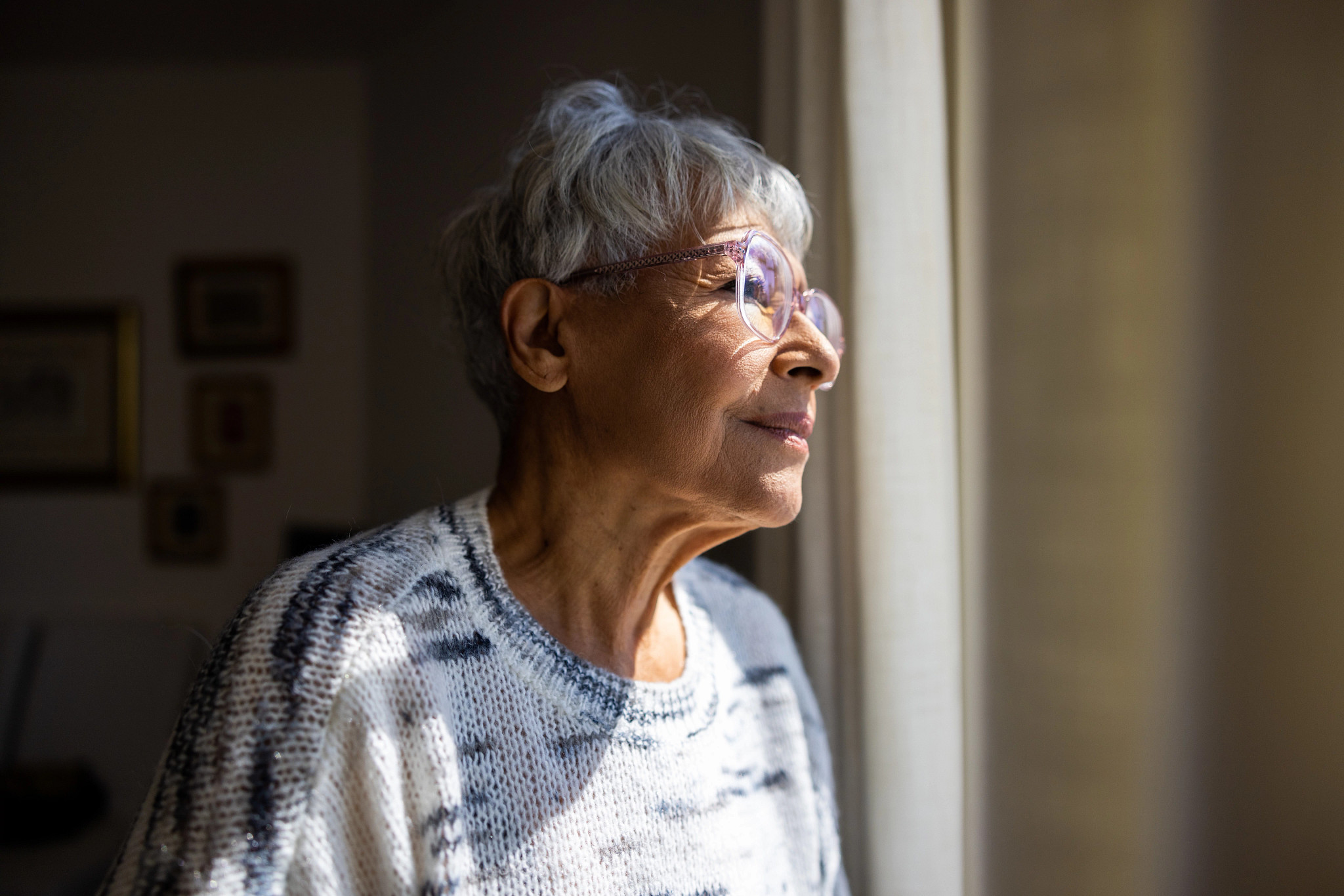 Image of an elderly woman looking out the window