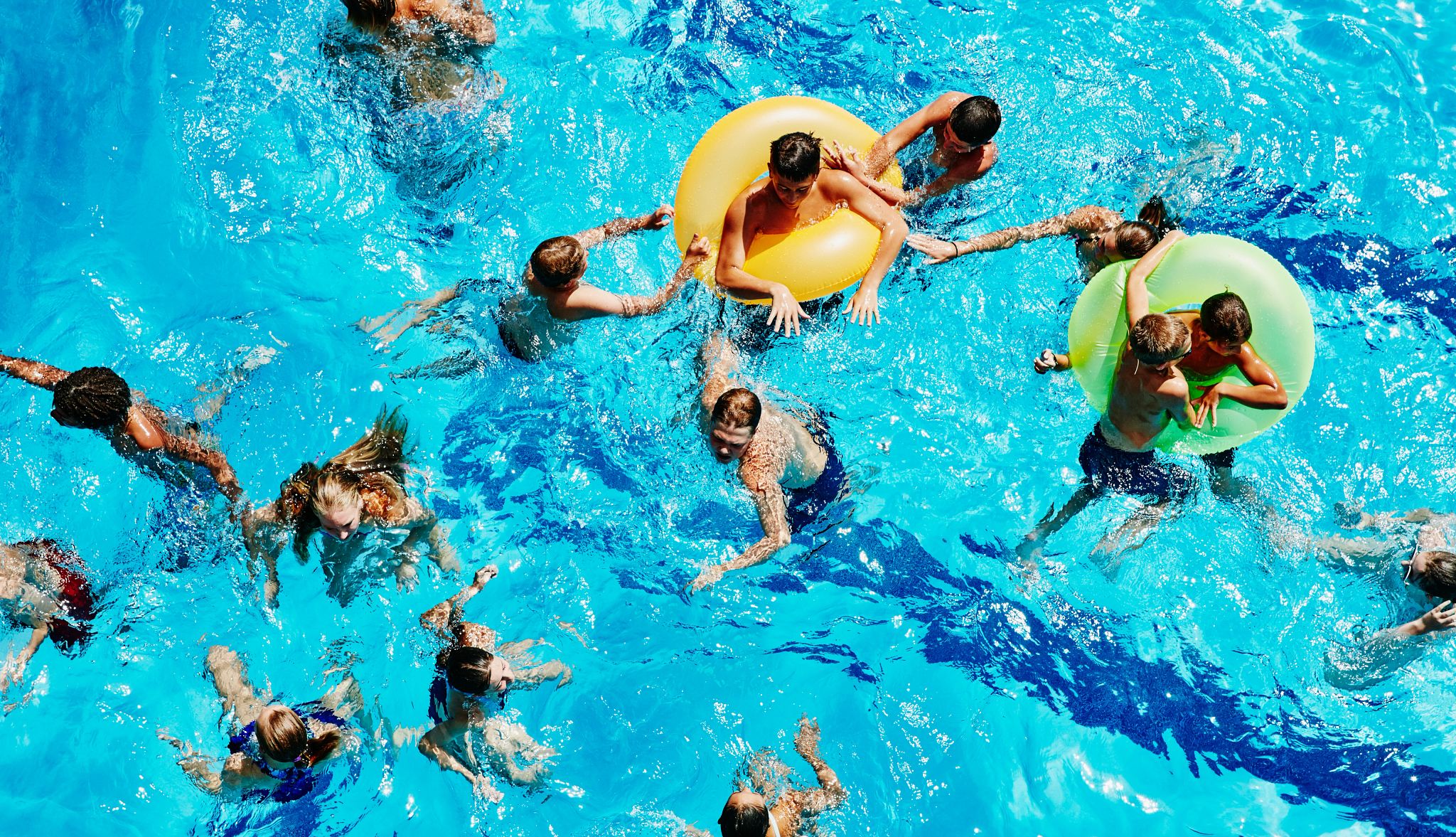A group of people in a pool from an overhead view. A group of people in a pool from an overhead view.