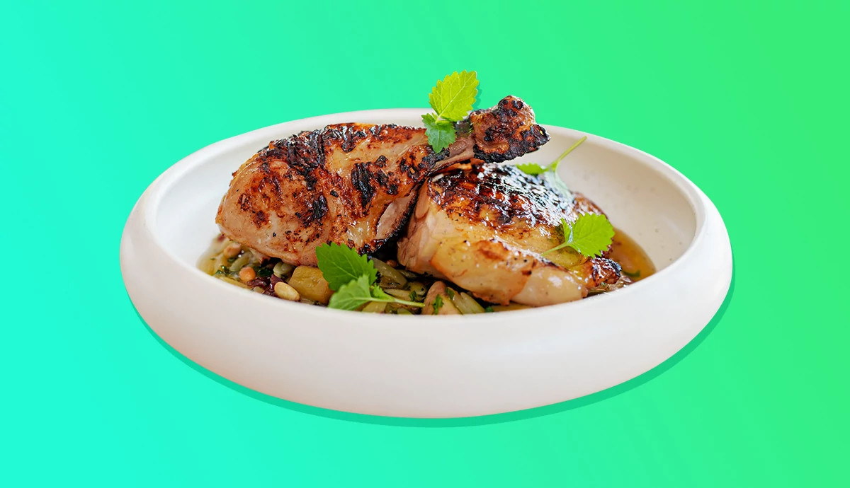 Roasted chicken drumstick and thigh served in a white bowl.
